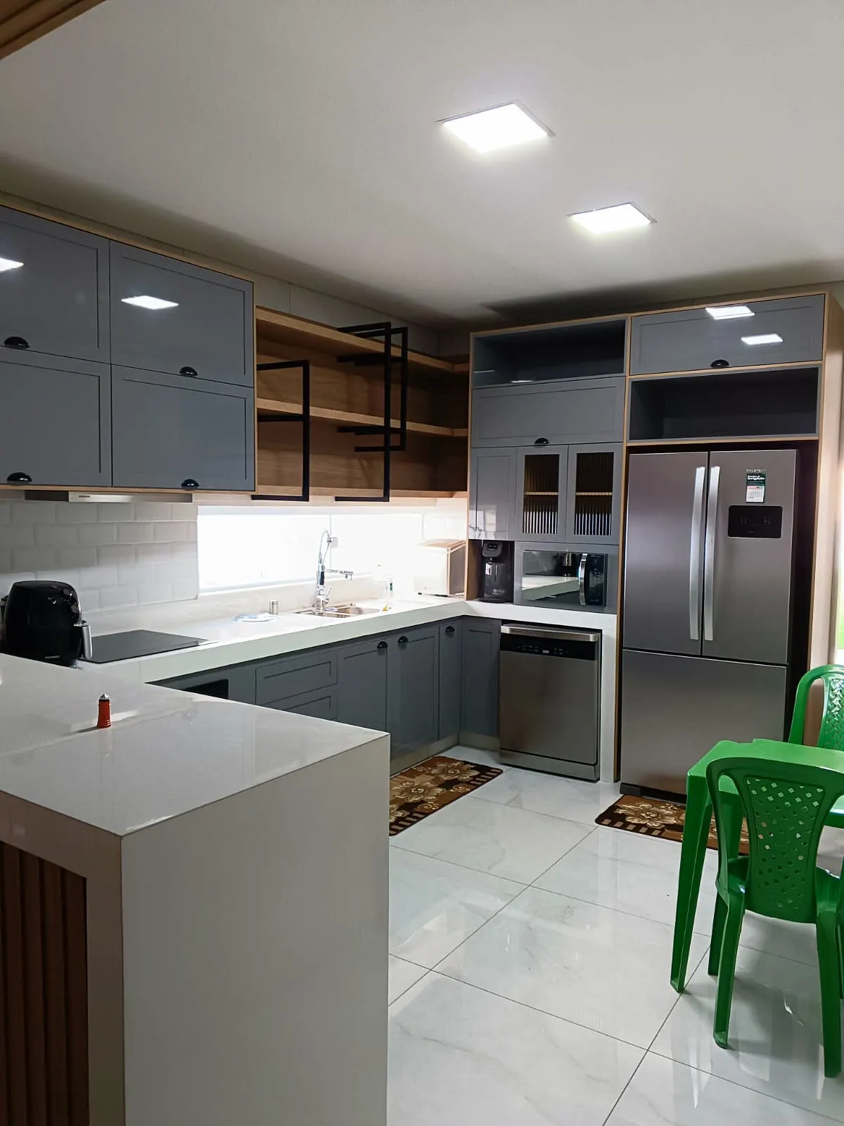Cozinha cinza com armários de vidro e nicho para geladeira