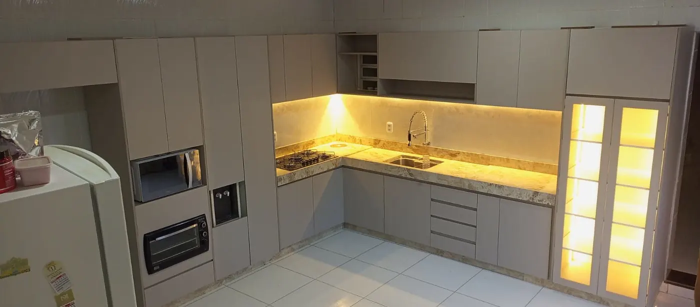 Cozinha clara com fita de LED sob os armários e cristaleira iluminada