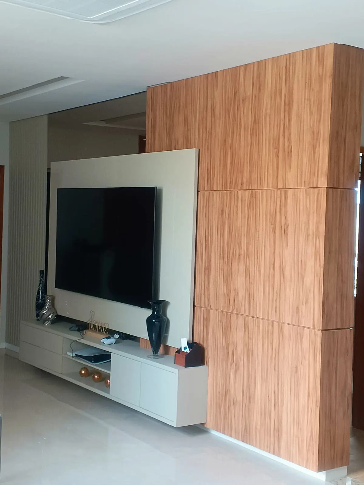 Painel de TV planejado com coluna revestida em madeira